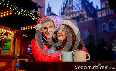 Young couple with drinks on Christmas market Stock Photo