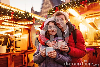 Young couple with drinks on Christmas market Stock Photo