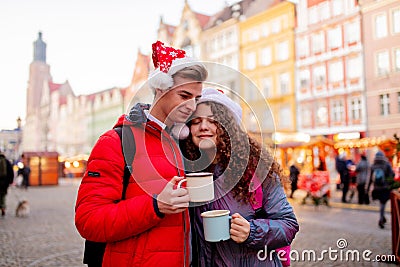 Young couple with drinks on Christmas market Stock Photo