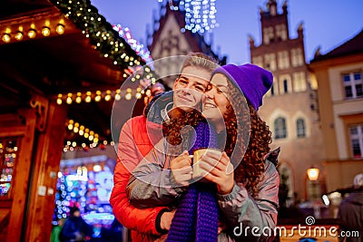 Young couple with drinks on Christmas market Stock Photo