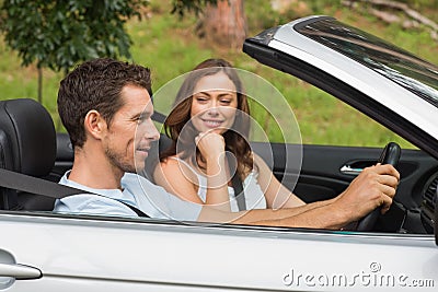 Young couple driving in a silver convertible Stock Photo