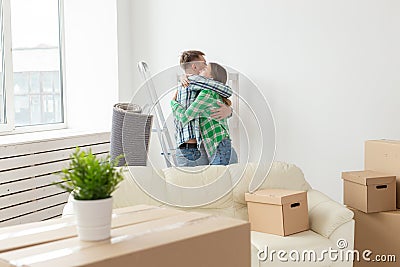 Young couple embraces and dances in the living room of their new apartment. The concept of affordable mortgage and new Stock Photo