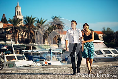 Young couple enjoying vacation time.Boyfriend and girlfriend having a romantic walk along the coast in a seaside town Stock Photo