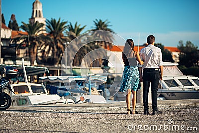 Young couple enjoying vacation time.Boyfriend and girlfriend having a romantic walk along the coast in a seaside town Stock Photo