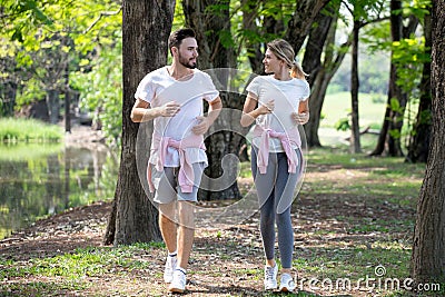 young couple fitness in sportswear running together in park . sport man and woman jogging outdoors in nature. workout ,exercising Stock Photo