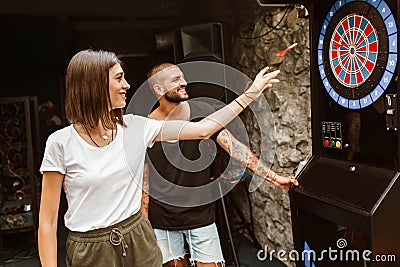 Couple flirting and playing darts Stock Photo