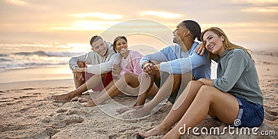 Young Couple With Friends In Casual Clothing On Vacation Sitting On Beach Watching Sunrise Together Stock Photo