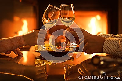 Young couple have romantic dinner with wine over fireplace background. Stock Photo