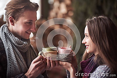 Young couple having breakfast in a romantic cabin outdoors in winter. Winter holiday and vacation. Christmas couple of Stock Photo