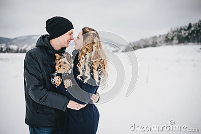 Young couple having a walk with their dog in snowy countryside Stock Photo