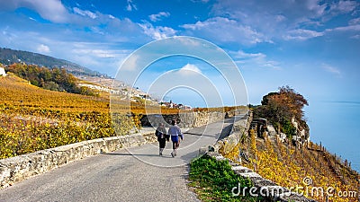 Young couple hiking in the beautiful Lavaux winery area near Chexbres, direction Montreux in Switzerland. Beautiful autumn colors Editorial Stock Photo