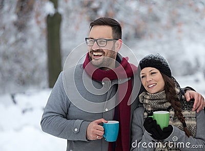 Man and woman with hot drink on snow Stock Photo