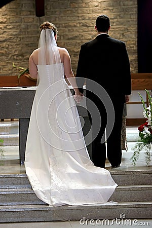Young Couple Holding Hands at Altar on Wedding Day Stock Photo