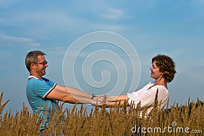 Young couple holds hands on a meadow Stock Photo
