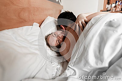 Beautiful happy young couple or family waking up together in bed Stock Photo