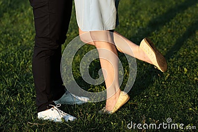 A young couple kissing in a backyard in summer sun light during sunset Stock Photo