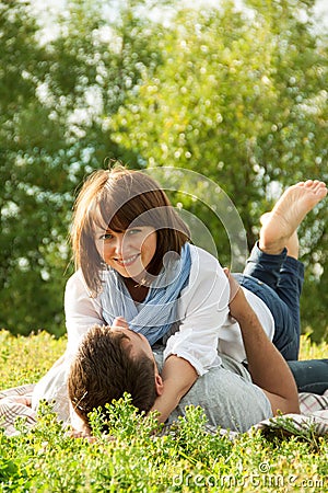 Young couple laying down in grass and hugging each other Stock Photo