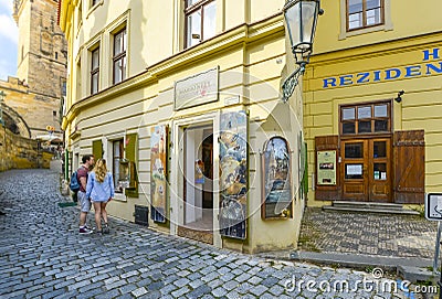 A young couple look in the window of a marionette and puppetry shop on Kampa Island in Prague, Czechia Editorial Stock Photo