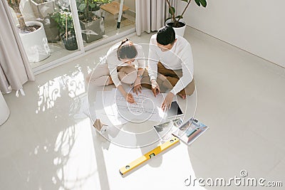 Young couple looking blueprints of they new house. Planning interior design Stock Photo