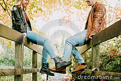 Young couple in love having fun and enjoying a walk in the autumn park. Focus on legs in boots. Selective focus, copy Stock Photo