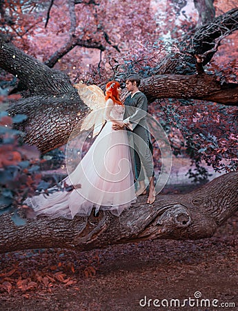 Young couple in love. A man and a woman are hugging on a huge tree. Themed creative wedding bright fantasy photography Stock Photo