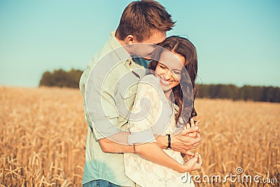 Young couple in love outdoor.Couple hugging.Young beautiful couple in love staying and kissing on the field on sunset. Stock Photo