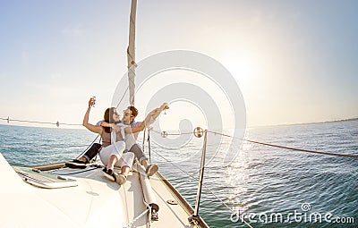 Young couple in love on sail boat with champagne at sunset - Hap Stock Photo