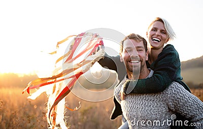 Young couple in love on a walk in autumn forest, holding hand ribbon kites. Stock Photo