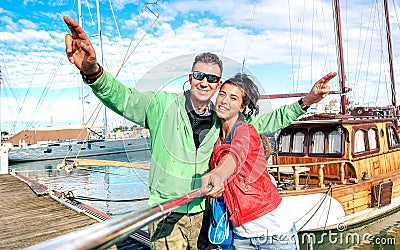 Young couple of lover taking selfie at sailboat docks on tour around world - Love concept with happy boyfriend and girlfriend Stock Photo