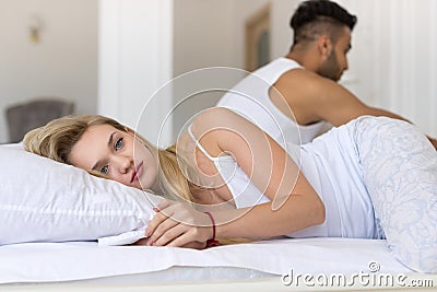 Young Couple Lying In Bed, Having Conflict Problem, Sad Negative Emotions Hispanic Man And Woman Stock Photo