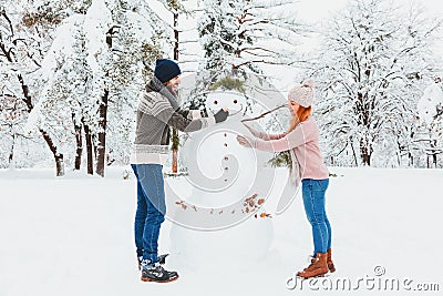 Young couple making snowman in the park Stock Photo