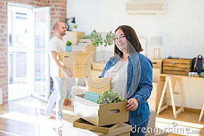 Young couple moving to new apartment, beautiful woman moving cardboard boxes and smiling happy Stock Photo