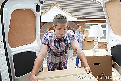 Young Couple Moving In To New Home Unloading Removal Van Stock Photo