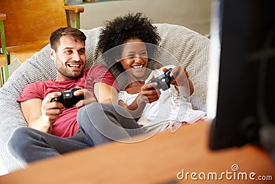 Young Couple In Pajamas Playing Video Game Together Stock Photo