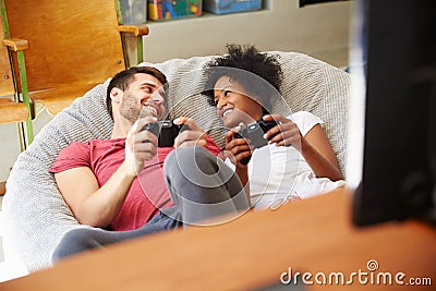 Young Couple In Pajamas Playing Video Game Together Stock Photo