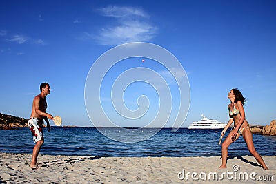 Young couple playing tennis on a beach. Stock Photo