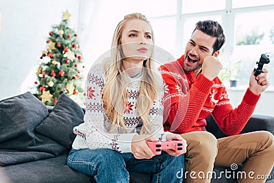 young couple playing video game with joysticks at home Stock Photo