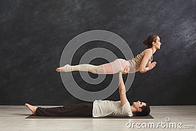 Young couple practicing acroyoga on mat together Stock Photo