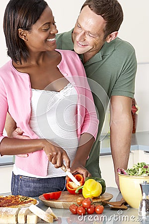 Young Couple Preparing Meal In Kitchen Stock Photo
