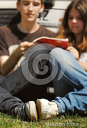 Young couple read the guidebook sitting near car Stock Photo