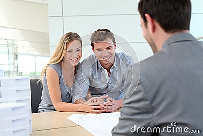 Young couple with realtor in agency Stock Photo