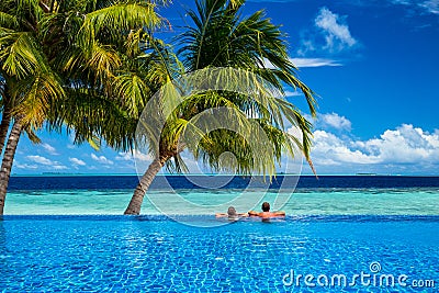 Young couple relaxing in infinity pool Stock Photo