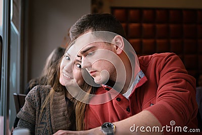 Young couple in a restaurant sitting at a table by the window and make an order. Two persons Stock Photo