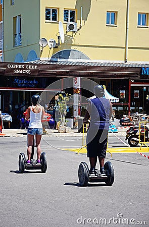 Couple riding segways, Vilamoura. Editorial Stock Photo