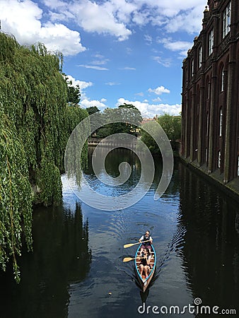 Young couple rowing down river Wensum, Norwich, Norfolk, East Anglia Editorial Stock Photo
