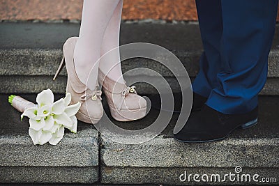 Young couple's legs. Woman and man in love. First date. Dating. Proposal. Lovers kissing. Beautiful calla lily flowers Stock Photo