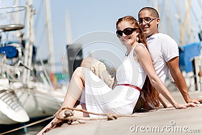 Young Couple Seated and Hugging On A Footbridge Stock Photo