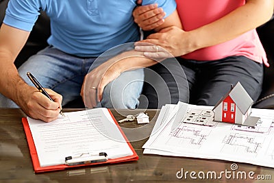 Young Couple Signing Loan Contract For A House Stock Photo