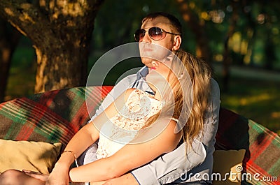 Young couple sitting on the garden bench Stock Photo