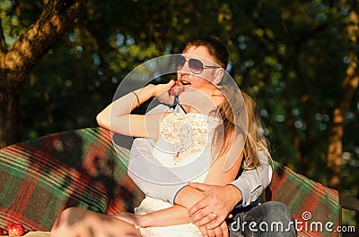 Young couple sitting on the garden bench Stock Photo